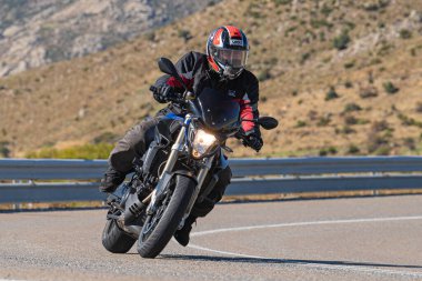 Bisikletiyle viraj alan bir motorcu. Fotoğraf 11 Kasım 2020 'de İspanya' nın Avila ilindeki Navalmoral limanında çekildi.