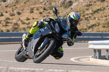 Bisikletiyle viraj alan bir motorcu. Fotoğraf 11 Kasım 2020 'de İspanya' nın Avila ilindeki Navalmoral limanında çekildi.