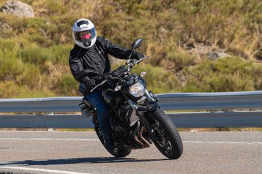Bisikletiyle viraj alan bir motorcu. Fotoğraf 11 Kasım 2020 'de İspanya' nın Avila ilindeki Navalmoral limanında çekildi.