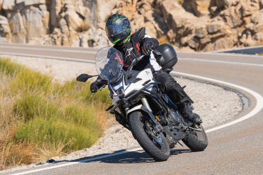 Bisikletiyle viraj alan bir motorcu. Fotoğraf 11 Kasım 2020 'de İspanya' nın Avila ilindeki Navalmoral limanında çekildi.