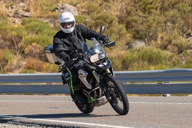 Bisikletiyle viraj alan bir motorcu. Fotoğraf 11 Kasım 2020 'de İspanya' nın Avila ilindeki Navalmoral limanında çekildi.