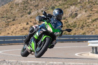 Bisikletiyle viraj alan bir motorcu. Fotoğraf 11 Kasım 2020 'de İspanya' nın Avila ilindeki Navalmoral limanında çekildi.