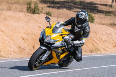 Bisikletinin üstünde yatan bir motorcu. Fotoğraf Ekim 2020 'de Avila, Spai' deki Cebreros kasabasında çekildi.