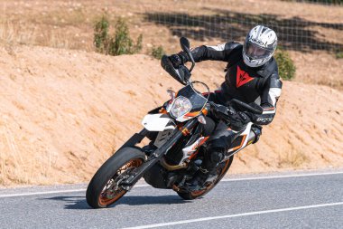 Bisikletinin üstünde yatan bir motorcu. Fotoğraf Ekim 2020 'de Avila, Spai' deki Cebreros kasabasında çekildi.