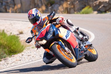 Motosikletli bir sürücü keskin bir viraj yapıyor. Fotoğraf 4 Temmuz 2021 'de Avila, Spai' deki Navalmoral limanında çekildi.