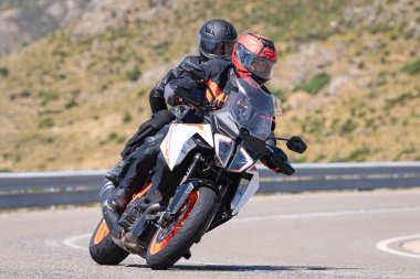 Motosikletli bir sürücü keskin bir viraj yapıyor. Fotoğraf 4 Temmuz 2021 'de Avila, Spai' deki Navalmoral limanında çekildi.