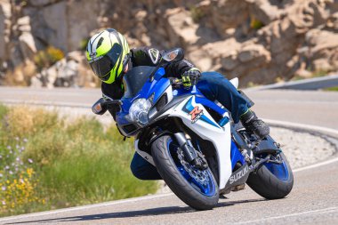 Motosikletli bir sürücü keskin bir viraj yapıyor. Fotoğraf 4 Temmuz 2021 'de Avila, Spai' deki Navalmoral limanında çekildi.