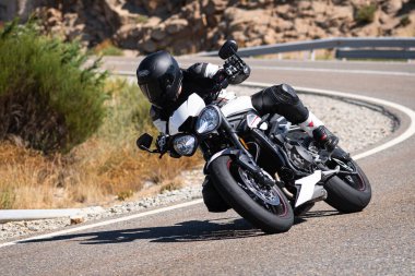 Ağustos 2020 'de İspanya' nın Avila ilindeki Navalmoral limanında güneşli bir pazar günü keskin bir viraj alan motosikletçi