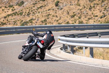 Ağustos 2020 'de İspanya' nın Avila ilindeki Navalmoral limanında güneşli bir pazar günü keskin bir viraj alan motosikletçi