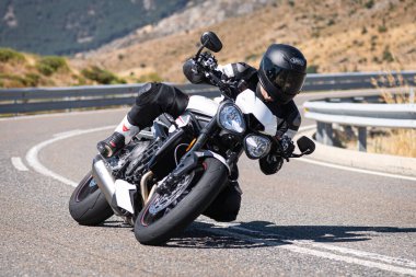 Ağustos 2020 'de İspanya' nın Avila ilindeki Navalmoral limanında güneşli bir pazar günü keskin bir viraj alan motosikletçi