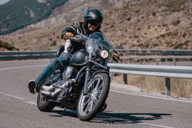 Ağustos 2020 'de İspanya' nın Avila ilindeki Navalmoral limanında güneşli bir pazar günü keskin bir viraj alan motosikletçi