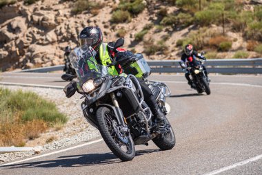 Ağustos 2020 'de İspanya' nın Avila ilindeki Navalmoral limanında güneşli bir pazar günü keskin bir viraj alan motosikletçi