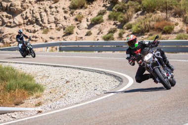 Ağustos 2020 'de İspanya' nın Avila ilindeki Navalmoral limanında güneşli bir pazar günü keskin bir viraj alan motosikletçi