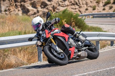 Ağustos 2020 'de İspanya' nın Avila ilindeki Navalmoral limanında güneşli bir pazar günü keskin bir viraj alan motosikletçi