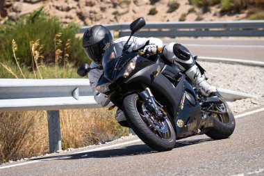 Ağustos 2020 'de İspanya' nın Avila ilindeki Navalmoral limanında güneşli bir pazar günü keskin bir viraj alan motosikletçi