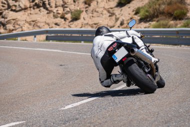 Ağustos 2020 'de İspanya' nın Avila ilindeki Navalmoral limanında güneşli bir pazar günü keskin bir viraj alan motosikletçi