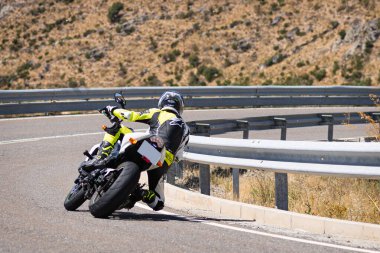 Ağustos 2020 'de İspanya' nın Avila ilindeki Navalmoral limanında güneşli bir pazar günü keskin bir viraj alan motosikletçi