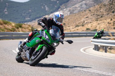 Ağustos 2020 'de İspanya' nın Avila ilindeki Navalmoral limanında güneşli bir pazar günü keskin bir viraj alan motosikletçi