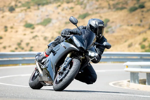 Keskin bir virajda motosikletinin kontrolünü kaybeden bir adam.