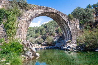 Görkemli antik Roma taş köprüsü, yükselen yükseklik vadiye tarihi kemerlerle hükmediyor.