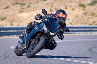 Ağustos 2023 'te İspanya' da virajlı bir dağ yolunda hızlı giden bir motorcu.