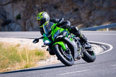 Ağustos 2023 'te İspanya' da virajlı bir dağ yolunda hızlı giden bir motorcu.