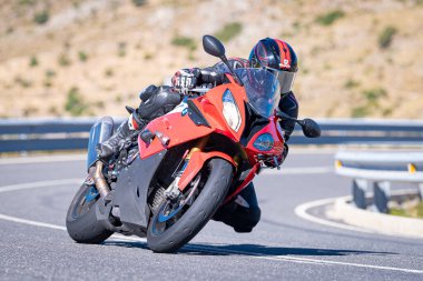 Ağustos 2023 'te İspanya' da virajlı bir dağ yolunda hızlı giden bir motorcu.