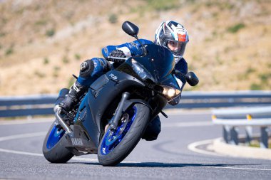 Ağustos 2023 'te İspanya' da virajlı bir dağ yolunda hızlı giden bir motorcu.