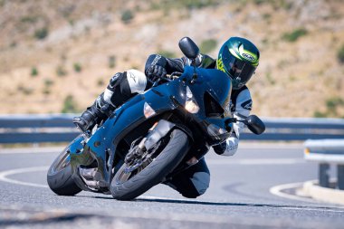 Ağustos 2023 'te İspanya' da virajlı bir dağ yolunda hızlı giden bir motorcu.