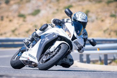 Ağustos 2023 'te İspanya' da virajlı bir dağ yolunda hızlı giden bir motorcu.