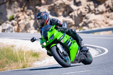 Ağustos 2023 'te İspanya' da virajlı bir dağ yolunda hızlı giden bir motorcu.