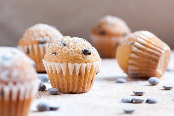 Muffins au chocolat isolés au premier plan sur table rustique en bois — Photo