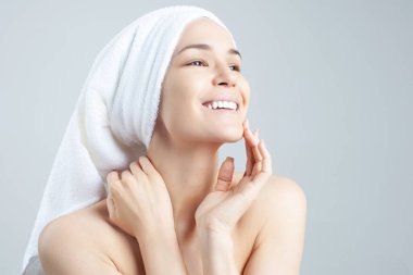 Saçında havlu olan tatlı, pozitif bir kız. Temizleme, nemlendirme, yüz derisi için kurs.