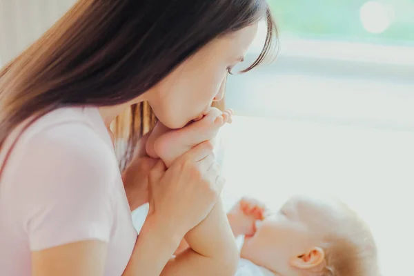 Giovane Madre Felice Bacia Piedi Del Suo Piccolo Bambino Cura — Foto Stock