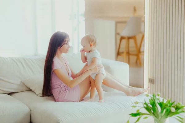 Giovane Bella Madre Gioca Con Suo Piccolo Bambino Sul Divano — Foto Stock