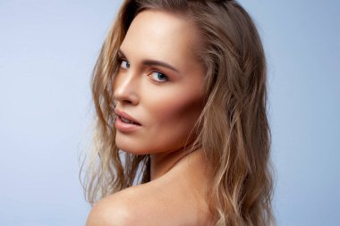 Dalgalı saçları olan güzel bir sarışın. Cilt bakımı, çıplak makyaj