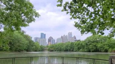 Piedmont Park, Midtown, Atlanta, GA, ABD 'den ağaçların manzarası ve güzel gökyüzü manzarası ve göl manzarası
