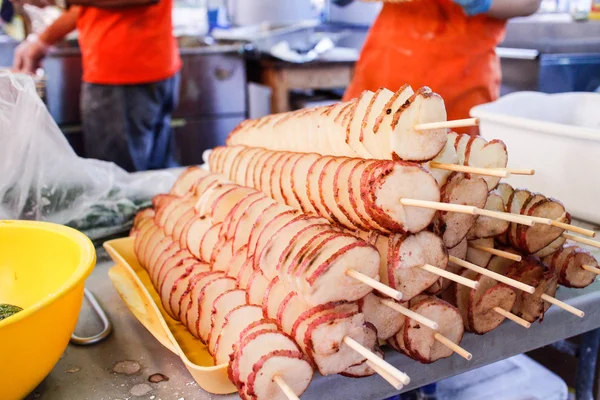 Wiggle chips on sticks at night market — Stock Photo, Image