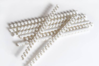 Bağlantı kağıtları için plastik yay yığını, beyaz arka planda yatıyor. Boşluğu kopyala.