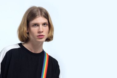 Kırmızımsı sarı saçlı, yeşil gözlü, omzunda gökkuşağı şeridi olan, ciddi ciddi kameraya bakan genç yakışıklı bir adam. Sıradan siyah. Hafif arkaplan, yumuşak seçici odak, kopyalama alanı, izole.