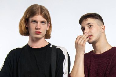 Ciddi bakışları olan iki yakışıklı genç adam. Arkadaş ya da çift, eşcinsel ilişki, genç ve farklı bir aile. Biri sarı saçlı, diğeri de esmer. Yumuşak seçici odak, kopyalama alanı, beyaz arkaplan.