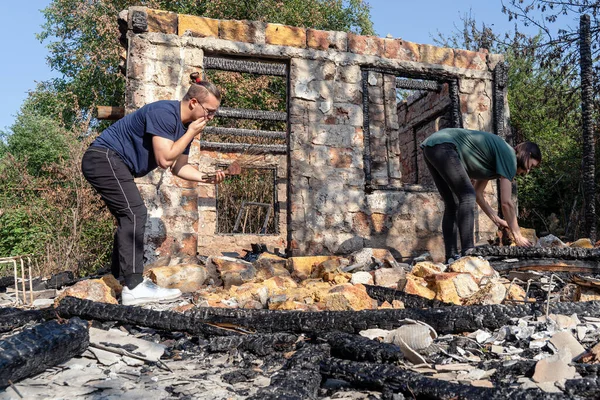 Jeune Couple Arrache Des Ruines Maison Détruite Par Feu Fenêtre Photo De Stock