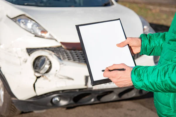 Space for text, blank document close up. An insurance agent will inspect and inspect vehicle damage after an accident. Inspection of the car after an accident on the road.