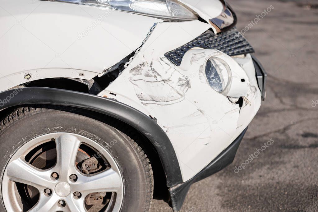 Inspection of the car after an accident on the road. Car accident or accident. The front wing and the right headlight are broken, damage and scratches on the bumper. Broken car parts or close-up.