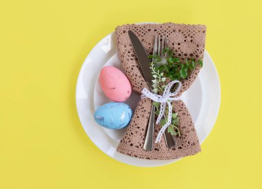 Mutlu Paskalyalar. Paskalya kutlaması. Üst manzara dikey peçete boş beyaz ve sarı plaka, paskalya yumurtaları, izole sarı arka plan. Boşluğu kopyala, metin için yer, pankart.