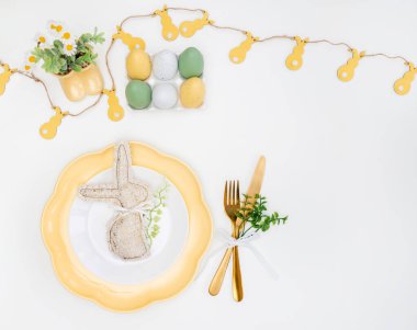 Mutlu Paskalyalar. Paskalya kutlaması. Dikey beyaz, sarı tabak, dekoratif tavşan, yumurta, izole beyaz arka plan. Boşluğu kopyala, metin için yer, pankart.