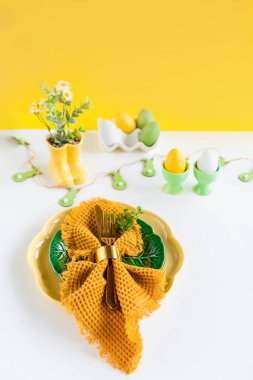 Mutlu Paskalyalar. Paskalya kutlaması. Üst manzara dikey peçete boş yeşil ve sarı plaka, paskalya yumurtaları, izole beyaz arka plan. Boşluğu kopyala, metin için yer, pankart.