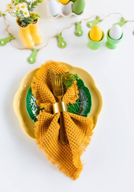 Mutlu Paskalyalar. Paskalya kutlaması. Üst manzara dikey peçete boş yeşil ve sarı plaka, paskalya yumurtaları, izole beyaz arka plan. Boşluğu kopyala, metin için yer, pankart.