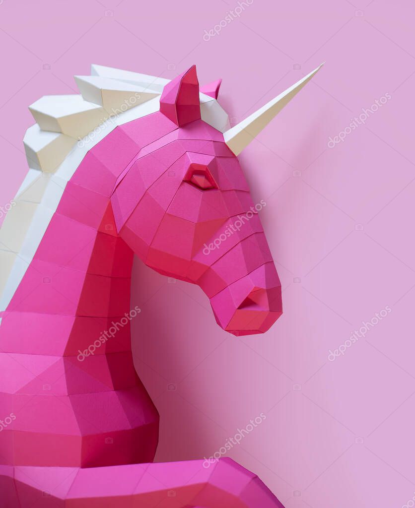 Pink paper geometric unicorn head. Made of paper. Innovative interior design details. Original geometric shape.
