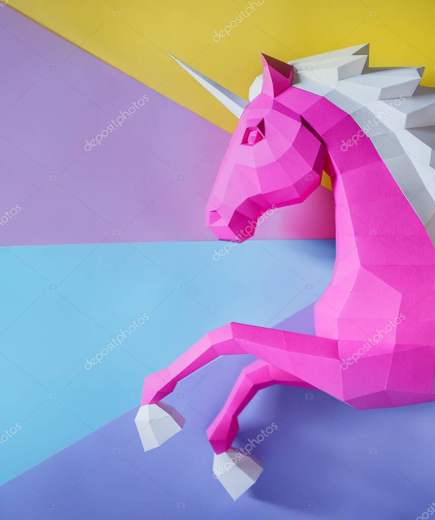 Pink paper geometric unicorn head. Made of paper. Innovative interior design details. Original geometric shape.
